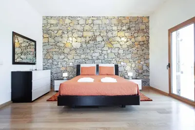 a bedroom with a bed and a stone wall at Casa Salir in Salir