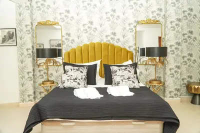 a bedroom with a bed with two lamps and mirrors at Seaside Serenity Villa in Albufeira