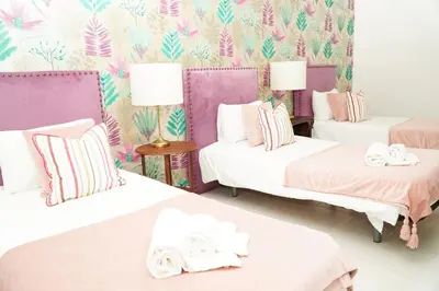 a room with three beds with pink and purple walls at Seaside Serenity Villa in Albufeira