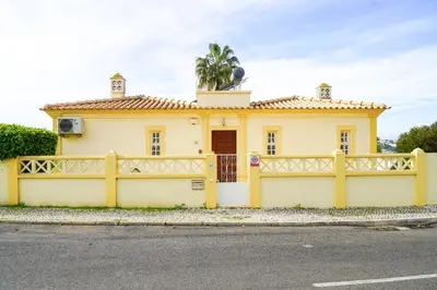 a yellow house with a fence in front of it at Seaside Serenity Villa in Albufeira