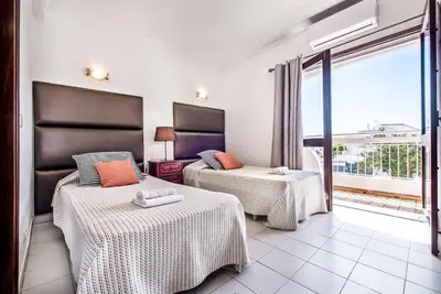 a hotel room with two beds and a balcony at Villa Canto in Albufeira