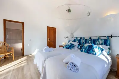 a bedroom with two beds with blue and white pillows at Casa Neel in Boliqueime