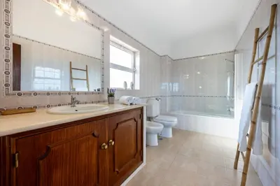 a bathroom with a sink and a tub and a toilet at Casa Neel in Boliqueime