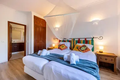a bedroom with a large white bed with towels on it at Casa Neel in Boliqueime