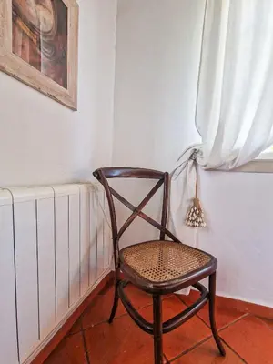 a chair sitting next to a radiator in a room at Villa Vale de Ursa - 16 - BY BEDZY in Sesmarias