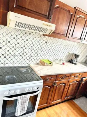 a kitchen with wooden cabinets and a white stove top oven at Beautiful Penthouse Two Bed Roof in Albufeira