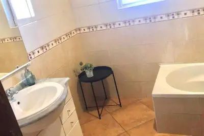 a bathroom with a sink and a stool next to a mirror at Beautiful Penthouse Two Bed Roof in Albufeira