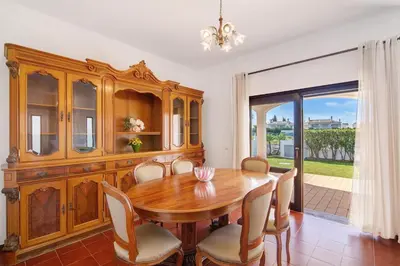 a dining room with a wooden table and chairs at Villa Luísa Galé in Albufeira