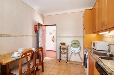 a kitchen with a sink and a table with chairs at Villa Luísa Galé in Albufeira