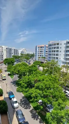 a street with cars parked in a city with buildings at NORA Studio in Quarteira