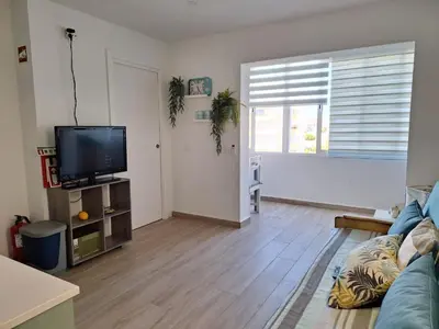 a living room with a couch and a flat screen tv at NORA Studio in Quarteira