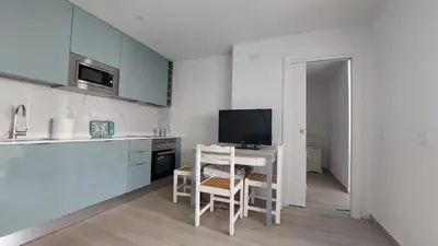 a kitchen with a table and a television in it at NORA Studio in Quarteira
