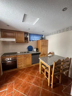 a kitchen with a table and a table and chairs at TAC - Açoteias Budget Studio in Olhos de Água