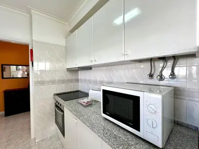 a kitchen with white cabinets and a microwave at Albufeira Concept 2 With Pool by Homing in Galé