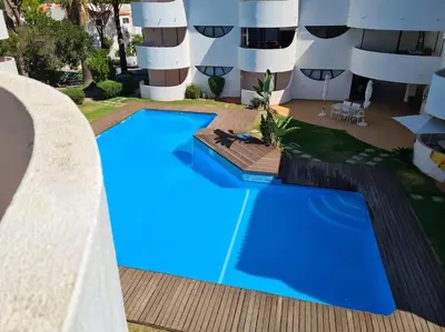 a large blue swimming pool next to a building at VILAMOURA APARTMENT NEAR MARINA AND BEACHES in Quarteira