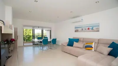 a living room with a couch and a table at Apartamento Oura Mar - By Dalma Portuguesa in Albufeira