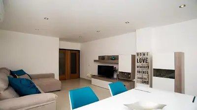 a living room with a couch and a table and chairs at Apartamento Oura Mar - By Dalma Portuguesa in Albufeira