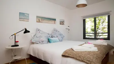 a bedroom with a white bed and a window at Apartamento Oura Mar - By Dalma Portuguesa in Albufeira