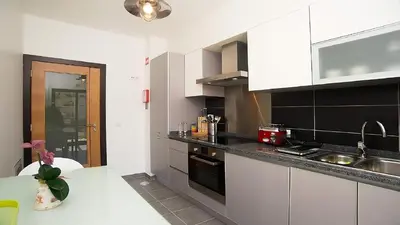 a kitchen with white cabinets and a counter top at Apartamento Oura Mar - By Dalma Portuguesa in Albufeira
