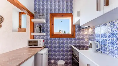 a kitchen with blue and white tiles on the wall at Comfy 2 BDR Apartment W/ Balcony by LovelyStay in Albufeira