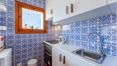 a small kitchen with blue tiled walls and a sink at Comfy 2 BDR Apartment W/ Balcony by LovelyStay in Albufeira