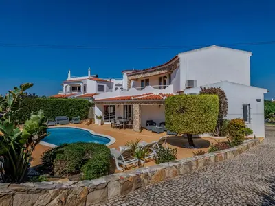 a villa with a swimming pool in front of a house at Holiday Home Paulo - VIP Properties by Interhome in Galé
