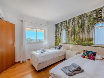 two beds in a room with two windows at Holiday Home Camélias VIP Properties by Interhome in Albufeira