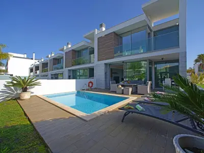 a swimming pool in front of a house at Villa Pires - VIP Properties by Interhome in Albufeira
