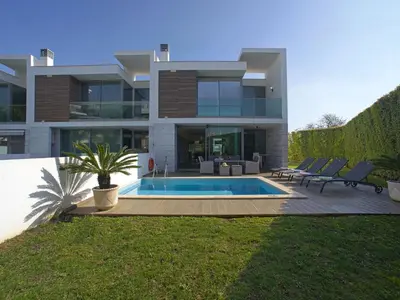 a house with a swimming pool in front of it at Villa Pires - VIP Properties by Interhome in Albufeira