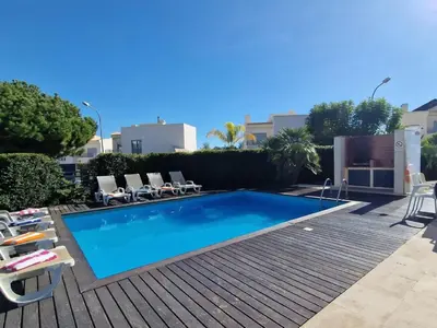 a large swimming pool with chairs and a deck at Villa Corcovada Lote 28 VIP Properties by Interhome in Albufeira