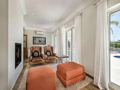 a living room with two chairs and a television at Amazing Algarve Villa 5 Bedrooms Villa Lillian Private Pool & Ping Pong in Almancil