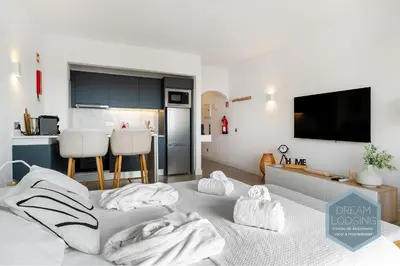 a white room with two beds and a table at Moai - Dream Lodging in Albufeira