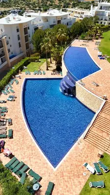 an overhead view of a large swimming pool with chairs at AlbufeiraOrada Cozy&Sunny Condo by BeCherish in Albufeira