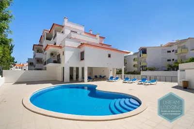 a villa with a swimming pool in front of a building at Miguel Torga - Dream Lodging in Albufeira