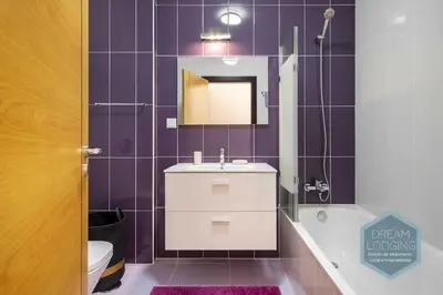 a bathroom with a sink and a mirror and purple tiles at Miguel Torga - Dream Lodging in Albufeira