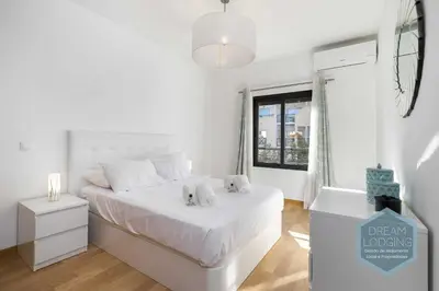 a white bedroom with a white bed and a window at Miguel Torga - Dream Lodging in Albufeira