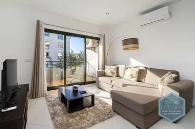 a living room with a couch and a tv at Miguel Torga - Dream Lodging in Albufeira