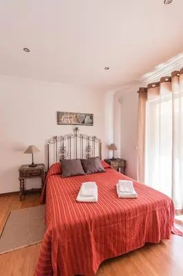 a bedroom with a red bed with two towels on it at Quinta Vita - Vila Limao in Almancil