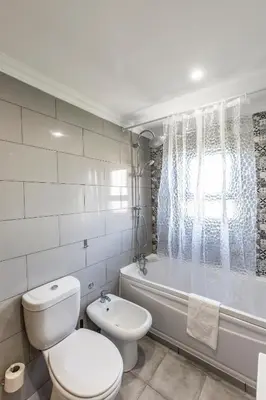 a white bathroom with a toilet and a bath tub at Quinta Vita - Vila Limao in Almancil