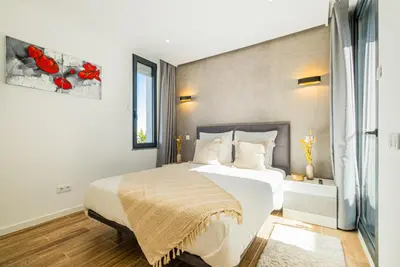 a bedroom with a large white bed and a window at Villa Kambole in Albufeira