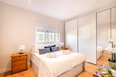 a white bedroom with a bed and a window at BeGuest Falésia Beach & Barbecue Apartment in Albufeira