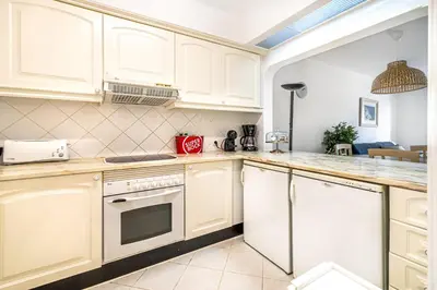 a kitchen with white cabinets and a stove top oven at BeGuest Balaia Apartment 137 in Albufeira