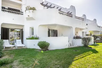 a white house with a yard with white chairs at BeGuest Balaia Apartment 137 in Albufeira