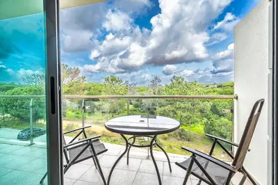 a patio with a table and chairs on a balcony at Monte Balaia AT19 Duplex - Pool View Olhos de Agua in Olhos de Água