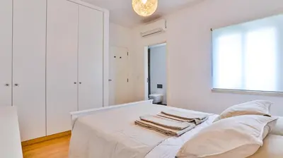 a white bedroom with a bed with towels on it at Apartamento T2 novo e espaçoso em Vilamoura in Vilamoura