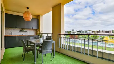a balcony with a table and chairs and a kitchen at Apartamento T2 novo e espaçoso em Vilamoura in Vilamoura