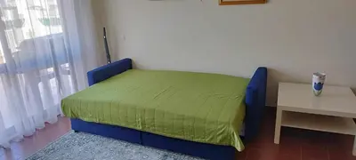 a bedroom with a bed with a green blanket on it at Albufeira INN - Lote 6 T1 in Albufeira