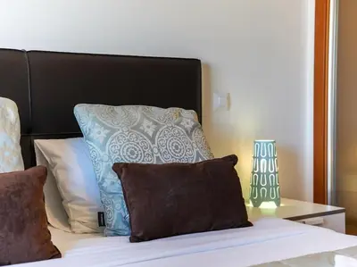 a bed with a blue and white pillow on it at Globe 33 Apartment by Stay ici Algarve Holiday Rental in Albufeira