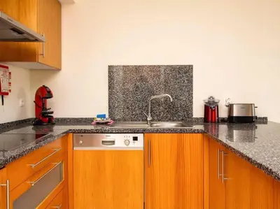 a kitchen with wooden cabinets and a sink at View Waves Apartment by Stay ici Algarve Holiday Rental in Albufeira