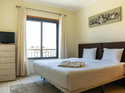 a bedroom with a large bed with a large window at View Waves Apartment by Stay ici Algarve Holiday Rental in Albufeira